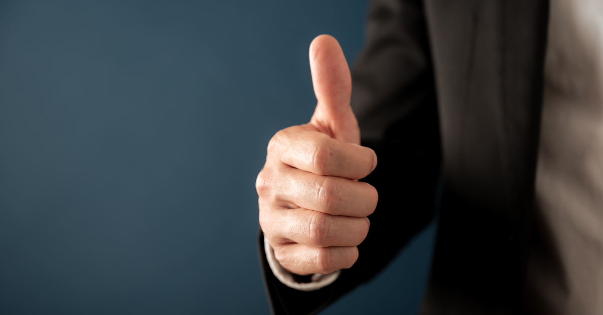 Businessman showing signal with thumb raised up